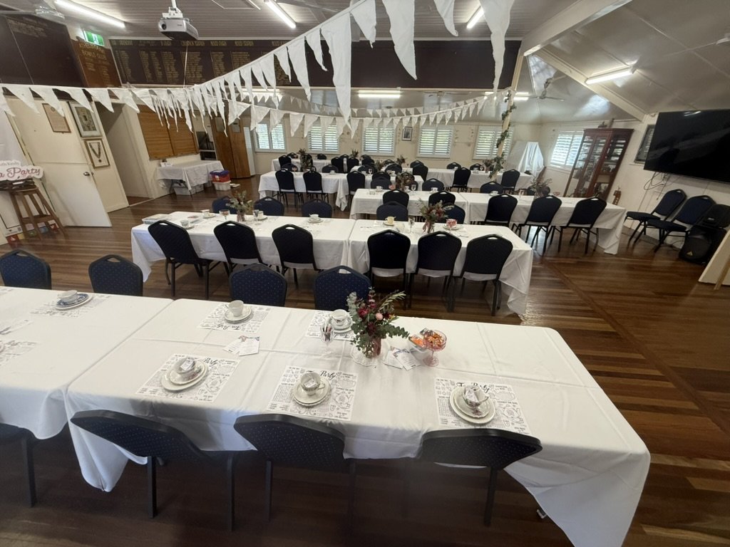 Function room at Athelstane House set up for an event, with long tables, white linen and bunting