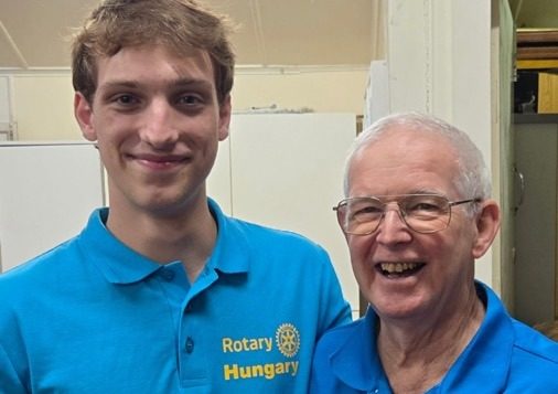 Young person wearing a Rotary Youth Exchange blazer with a Rotarian